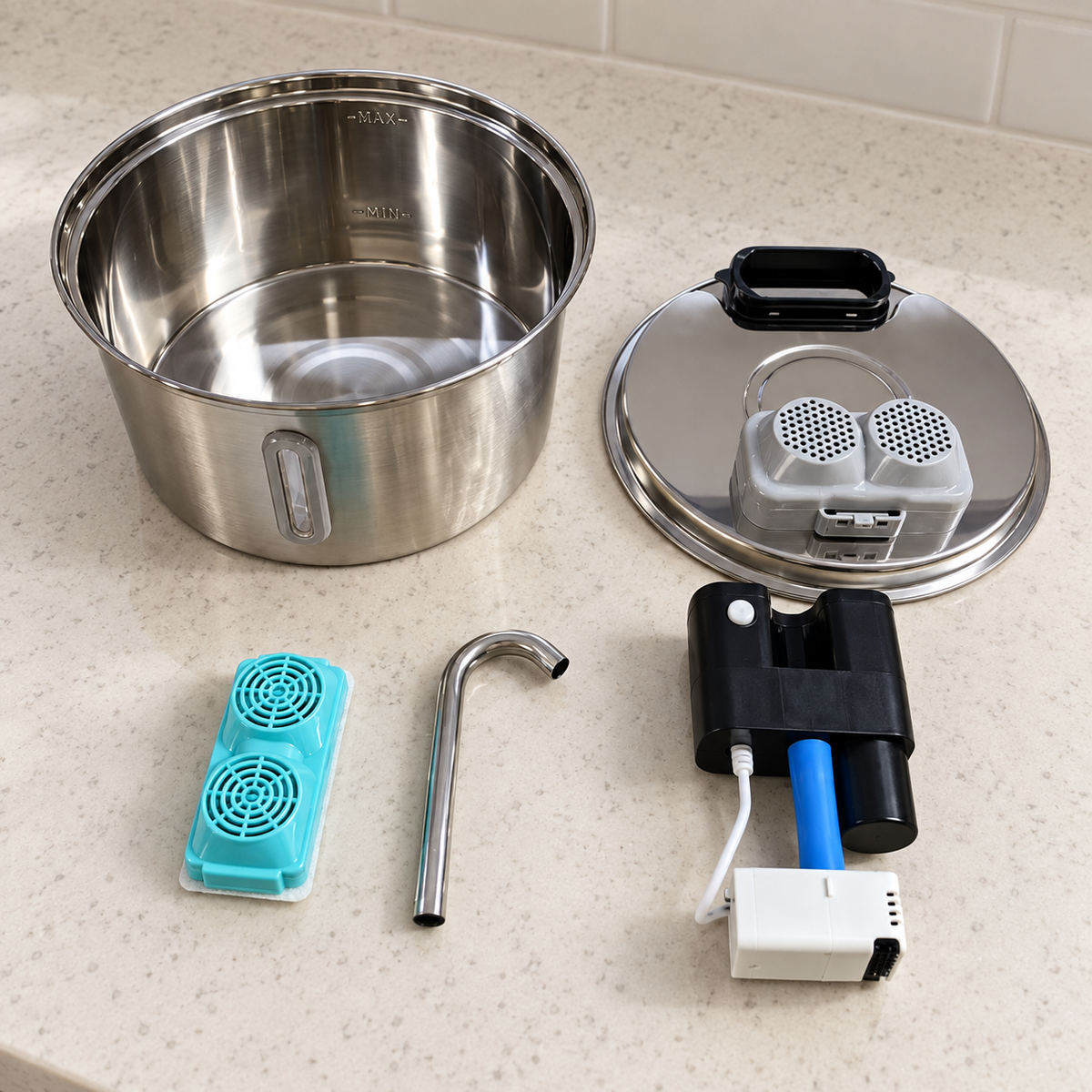 PurrCurrent tank and tray separated on a light countertop, with the filter, spout, pump and electronics set aside.